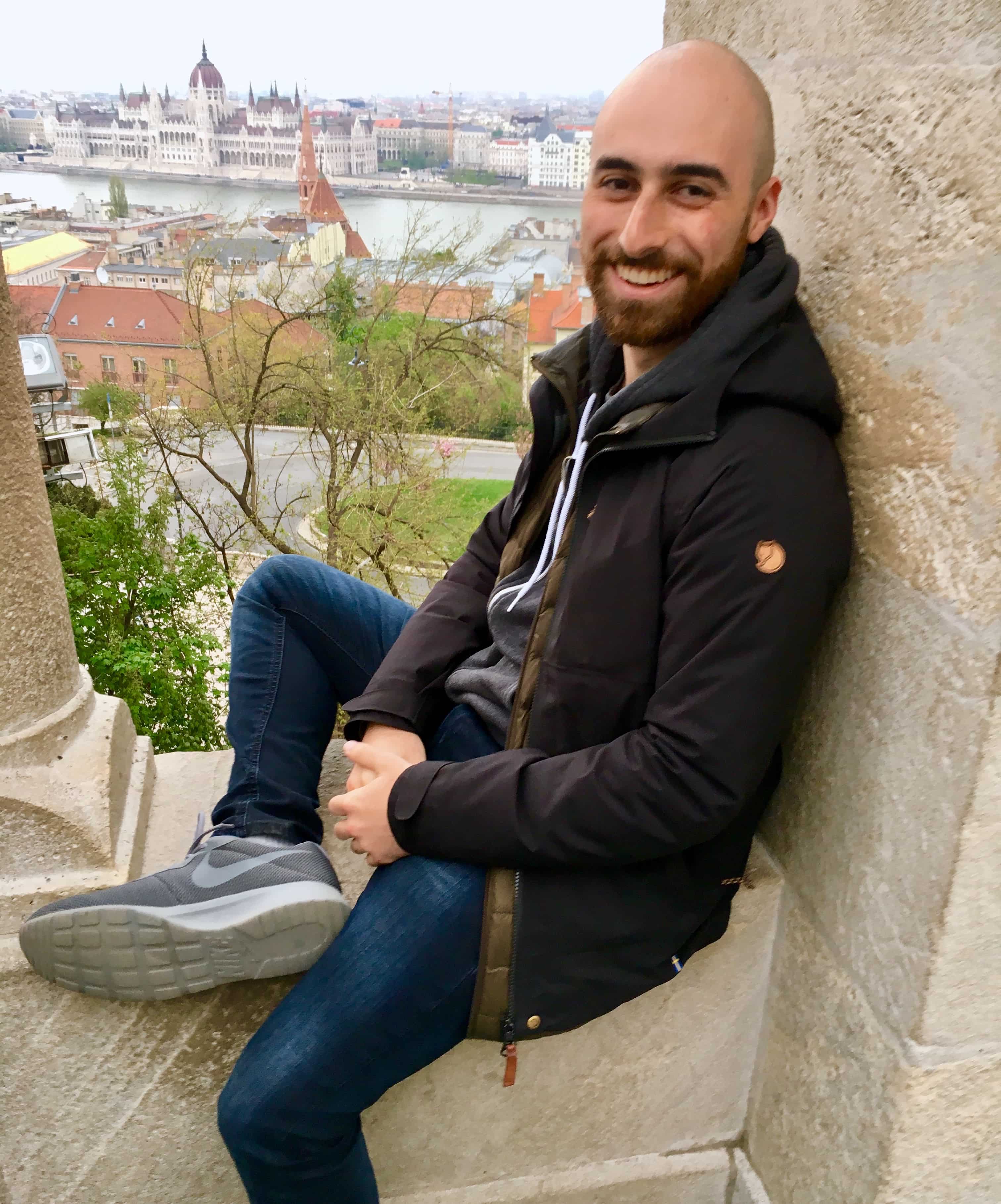 A handsome young bald gentleman overlooking the city of Prague